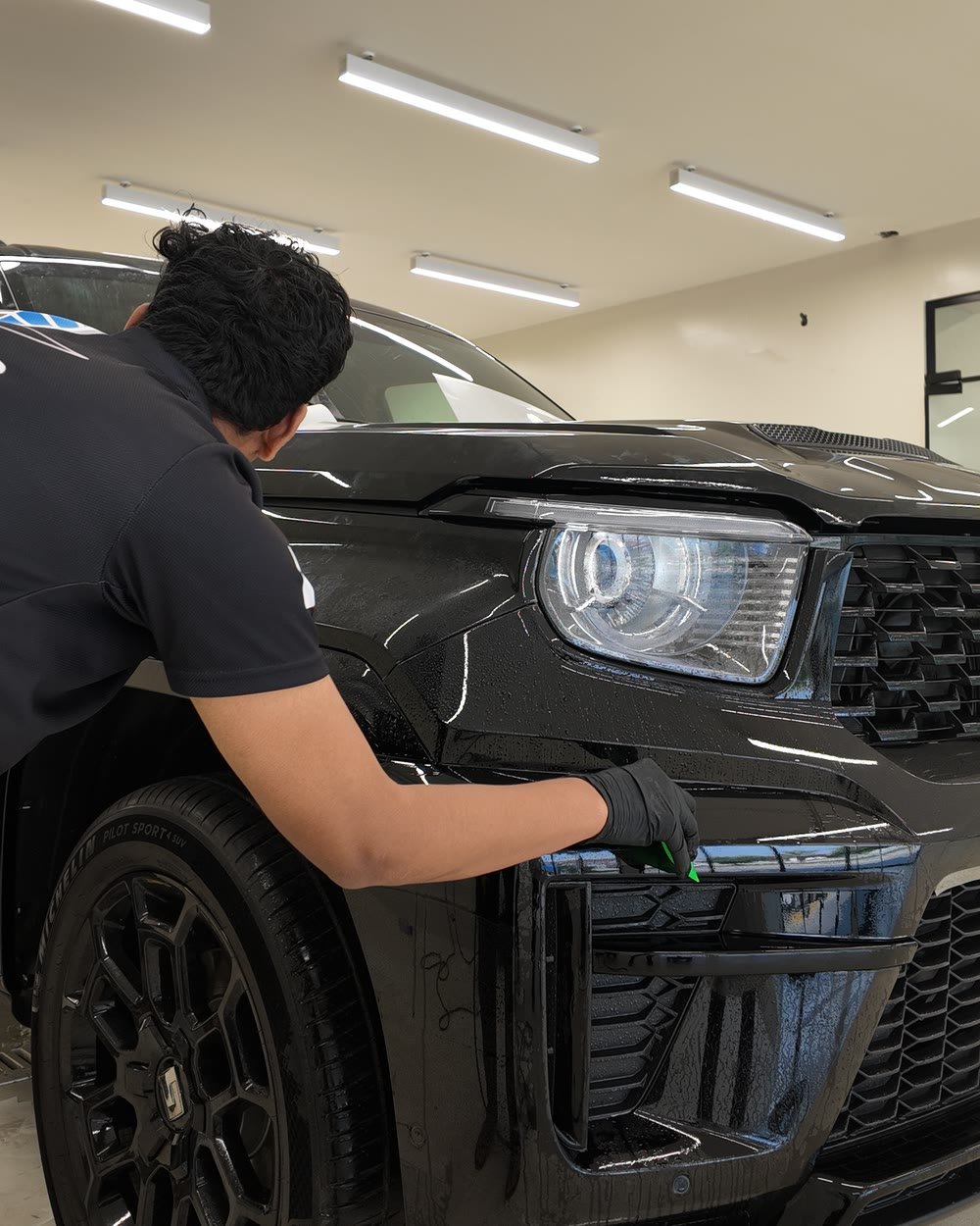 Smart Shield technician fitting ClearPro film around the headlight of a Tank 700